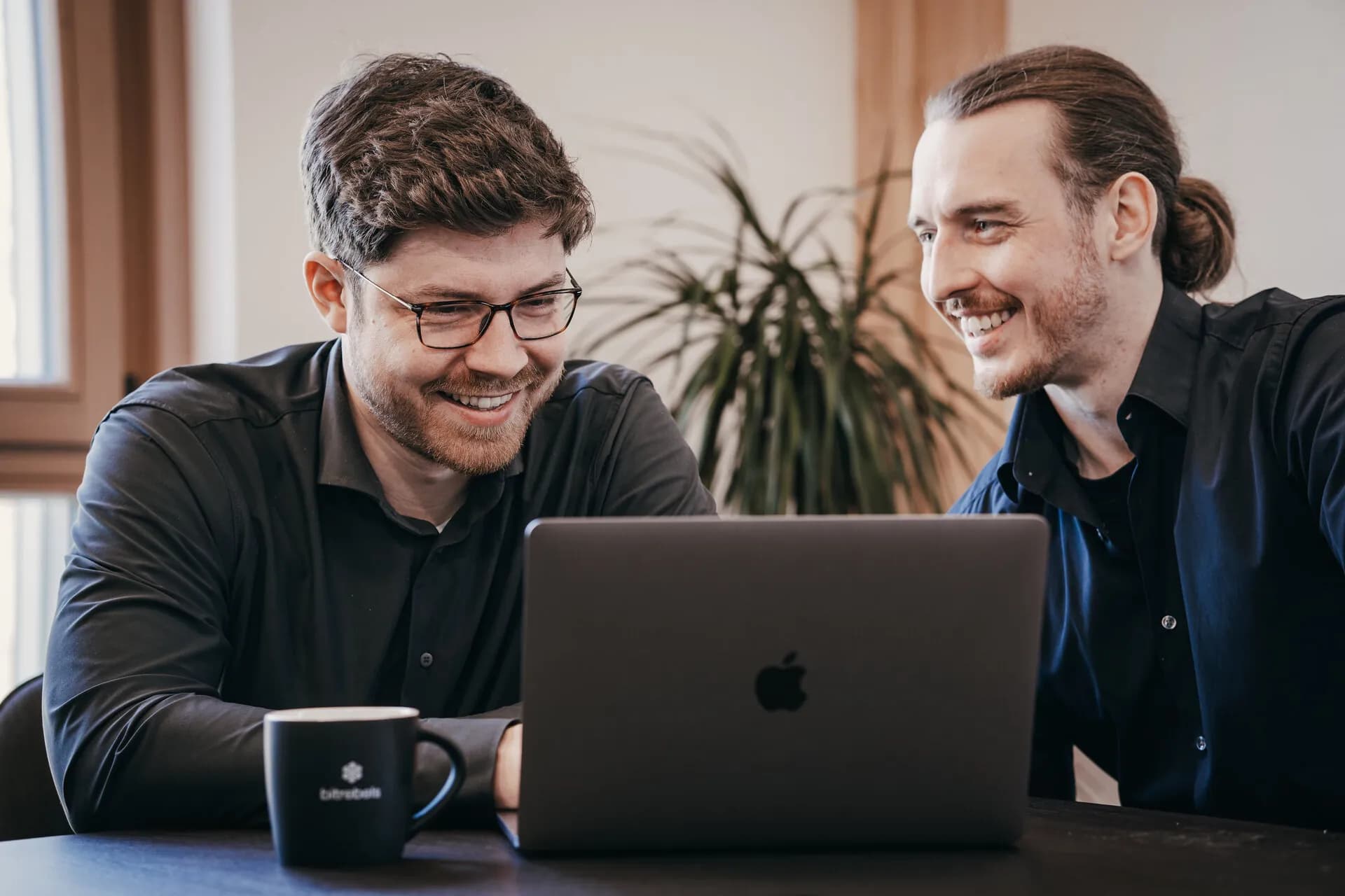 Lucas Engelke und Sebastian Weiß besprechen ein Projekt am Laptop